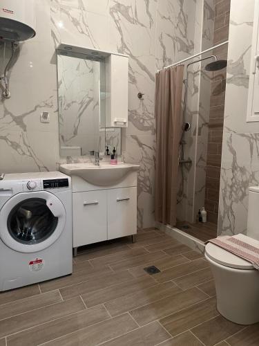 a bathroom with a washing machine and a sink at Kinfeels’ Downtown Suite ( K3 ) in Larisa