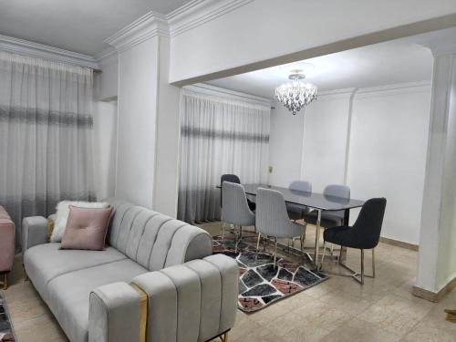 - un salon avec un canapé, une table et des chaises dans l'établissement Luxury Apartment near cairo airport, au Caire
