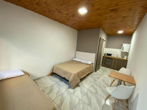 een kamer met een bed, een tafel en een stoel bij El viejo LEPI Aparts in El Calafate