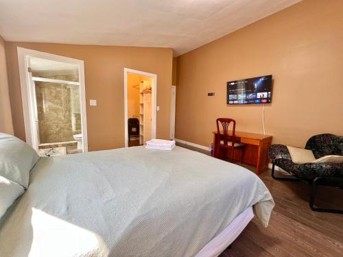 ein Schlafzimmer mit einem großen Bett und einem Flachbild-TV in der Unterkunft Newly Renovated Home in Central Aurora in Aurora