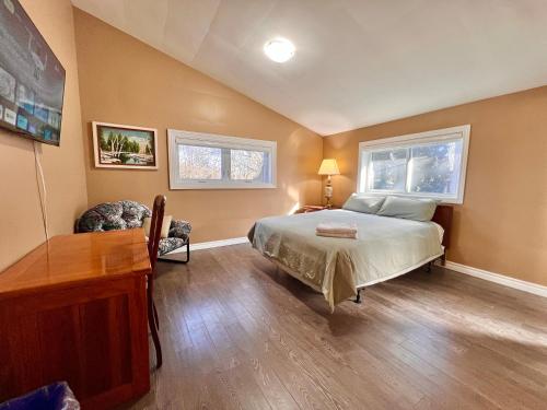 una camera da letto con un letto, una scrivania e due finestre di Newly Renovated Home in Central Aurora a Aurora