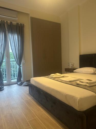 a bedroom with two beds and a large window at Kinfeels’ Downtown Suite ( K3 ) in Larisa