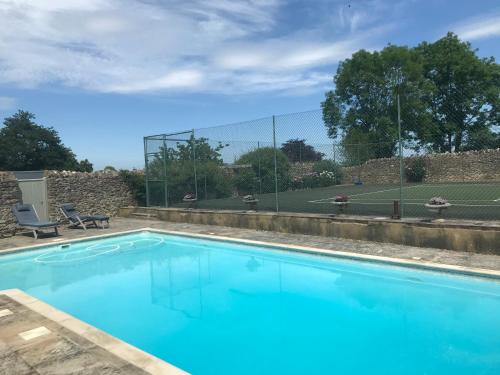 uma piscina com água azul em frente a uma cerca em Helmdon House Bed and Breakfast em Helmdon