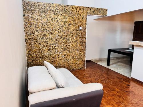 Casa para Férias في إنهامبان: غرفة معيشة مع أريكة بيضاء مقابل جدار