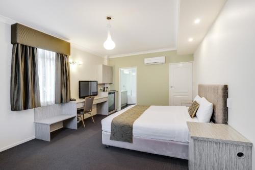 a hotel room with a bed and a desk at Prince of Wales Hotel in Wagga Wagga