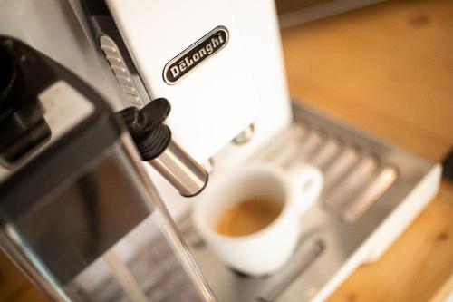 a cup of coffee is coming out of a toaster oven at Guest House Camilla in Alghero