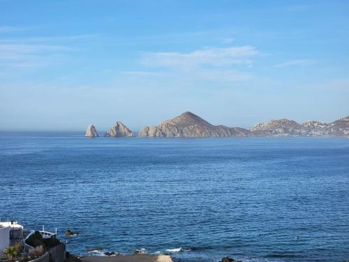 a large body of water with mountains in the background at Oceanfront Penthouse, 2 Masters, 2 Baths, kitchen! in Cabo San Lucas