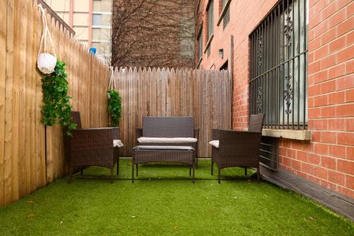 patio z 4 krzesłami i ogrodzeniem w obiekcie American Dream Guest House w Nowym Jorku
