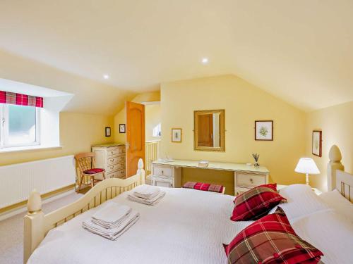 a bedroom with a large white bed with red pillows at 2 Bed in Lyonshall 93321 in Lyonshall