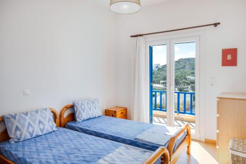 a bedroom with two beds and a balcony at Villa Zenia Syros in Vári