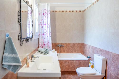 a bathroom with a sink and a toilet and a tub at Villa Zenia Syros in Vári