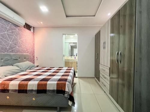 ein Schlafzimmer mit einem Bett und einem Kleiderschrank in der Unterkunft Apartamento Térreo Charmoso in Cabo Frio
