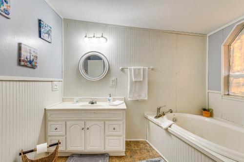 W łazience znajduje się umywalka, wanna i lustro. w obiekcie Pensacola Home with Private Dock - 7 Mi to Beaches w mieście Pensacola