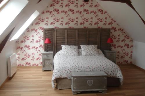 a bedroom with a bed with red floral wallpaper at Gîte 3 étoiles Le Clos des Tilleuls in La Vendelée