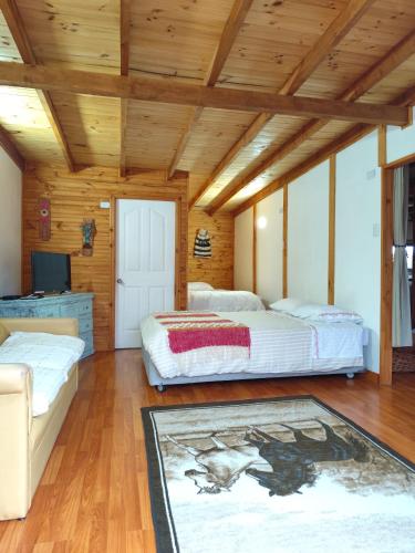 two beds in a room with wooden ceilings at Departamento acogedor in Quellón