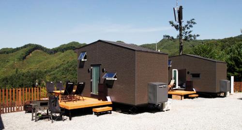a tiny house with a picnic table and chairs at Starium Jecheon in Jecheon