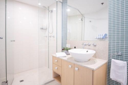 uma casa de banho com um lavatório e um chuveiro em Panoramic Ocean Views At Maroochydore em Maroochydore