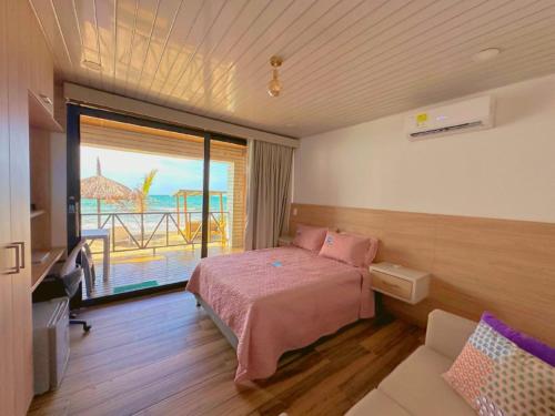 SUITE OCEAN VIEW - PLAYA في تولو: غرفة نوم مع سرير وإطلالة على المحيط