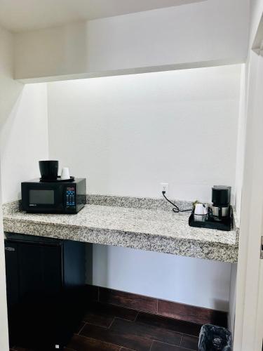 a microwave sitting on a counter in a room at Lonestar Inn in El Campo