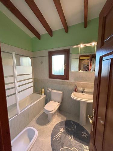a bathroom with a white toilet and a sink at Sweet Home in Pego