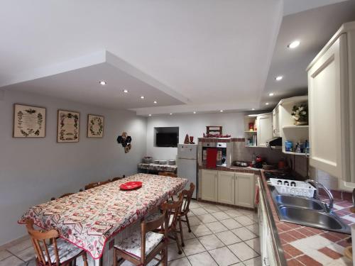 cocina con mesa con sillas y fregadero en Casa Vacanze Minula - Indipendent Country House, en Carnello