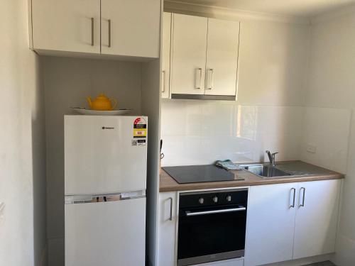 a kitchen with a white refrigerator and a sink at The Stables at Rosevale in Bathurst