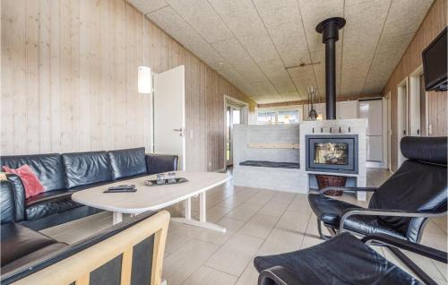 a living room with a couch and a table and a fireplace at Holiday Home Råde Strandpark Vi in Årøsund