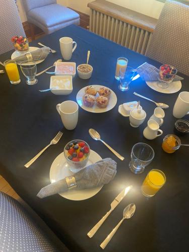 a table with plates and bowls of food on it at North of Avon B&B Suites in Stratford