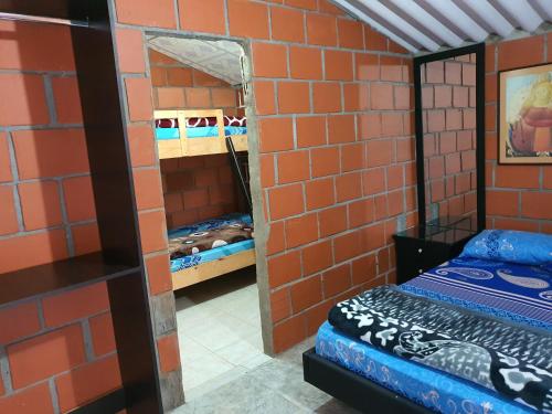 a brick walled room with a mirror and a bed at la hogareña in Calima