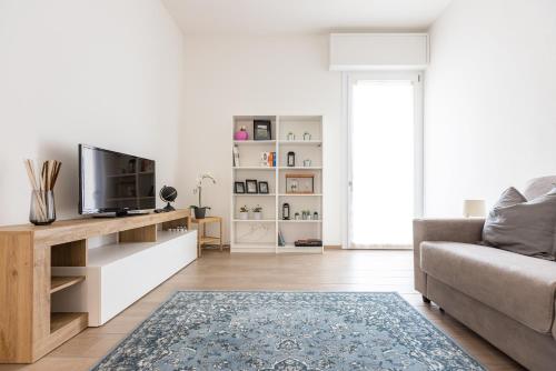 uma sala de estar com um sofá e uma televisão em Molinari House Modena Rubino em Modena