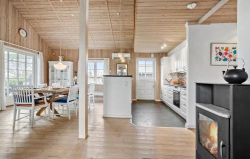 a kitchen and dining room with a table and a refrigerator at 3 Bedroom Pet Friendly Home In Højslev in Højslev