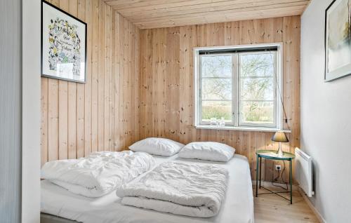 two beds in a room with wooden walls at 3 Bedroom Pet Friendly Home In Højslev in Højslev