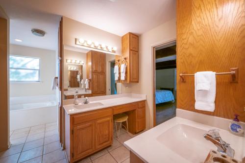 a bathroom with a sink and a tub at Guadalupe River Getaway - 140 Feet of Beautiful Waterfront! in New Braunfels