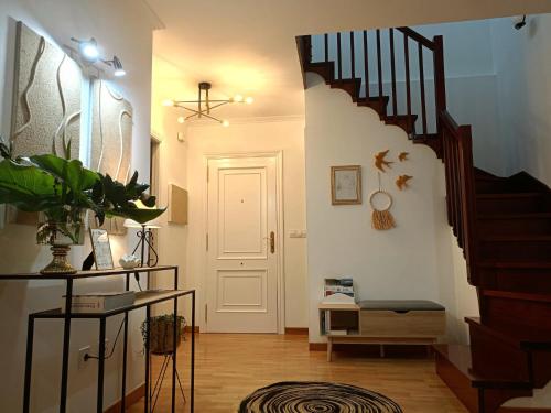 a hallway with a staircase and a white door at As Conchas in Vilagarcia de Arousa