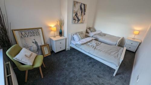 a small bedroom with two beds and a chair at The road to Wigan Pier in Pemberton