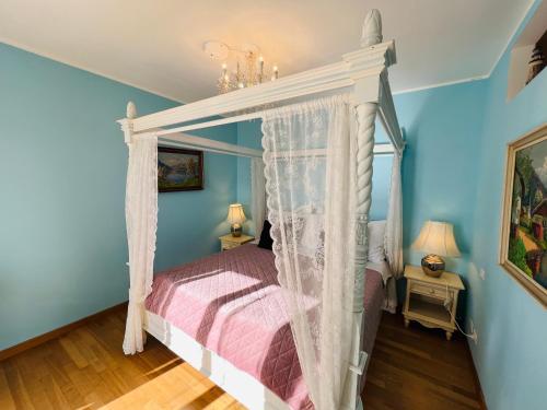 a bedroom with a canopy bed and blue walls at Esmaraldas House of Love in Terrasini