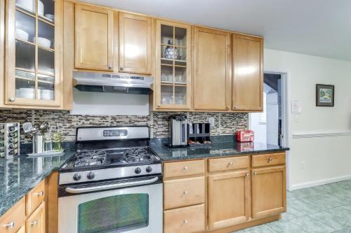 a kitchen with wooden cabinets and a stove top oven at Family-Friendly Home in Bowie with Fenced Yard! in Bowie