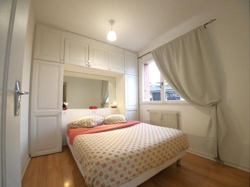 1 dormitorio con cama con espejo y ventana en Paradise Apartment near downtown lake & Free Parking - local bike, en Annecy