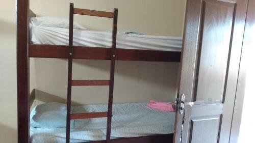 a bunk bed room with two bunk beds and a door at Casas Aluguel Temporada Pousada Village Maçarico in Salinópolis