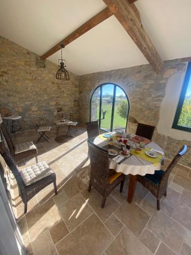 a dining room with a table and chairs at Le Mas Vivarés in Lablachère