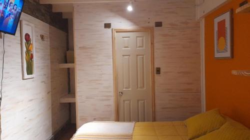 Habitación pequeña con cama y puerta en Manhuemalal, en Villarrica