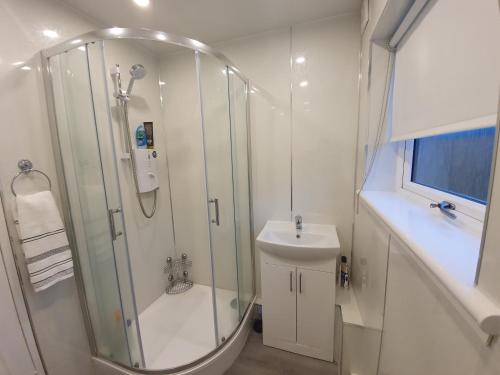 a white bathroom with a shower and a sink at Homie in Aberdeen