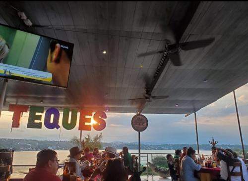 a crowd of people sitting at a bar watching a tv at Glamping Teques Naturaleza de lujo Granja El Sol in Xoxocotla
