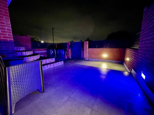 un patio vacío por la noche con luces azules en Luxury 6 Bedroom House, all with En-suite bathroom - West London - Wembley Stadium, OVO Arena 5 km, en Greenford