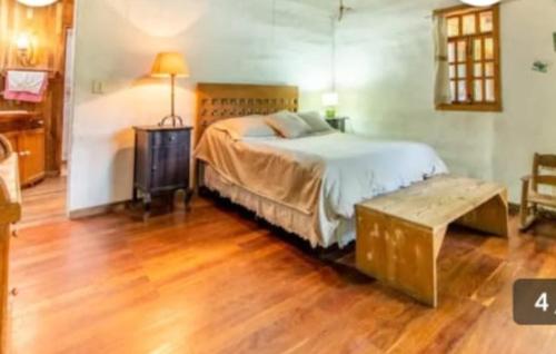 a bedroom with a bed and a wooden floor at Glamping Teques Naturaleza de lujo Granja El Sol in Xoxocotla