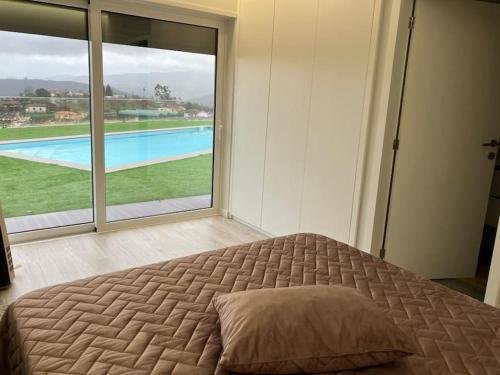 um quarto com uma cama grande e uma janela grande em Varandas da Vista Alegre em Arouca