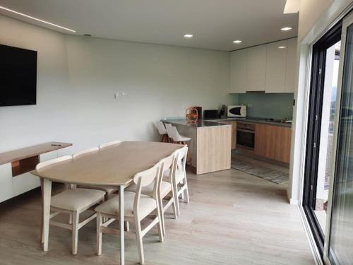 a kitchen and dining room with a table and chairs at Varandas da Vista Alegre in Arouca