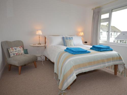 a bedroom with a bed and a chair and a window at 2 Bed in Bude AGLET in Bude