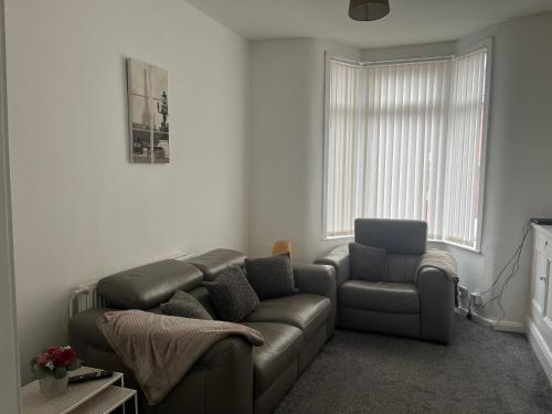 a living room with a couch and a chair at Modern 2 bed sleep 5 close to Anfield Stadium in Liverpool