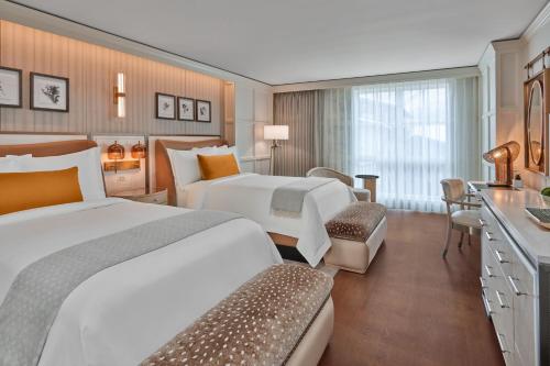 a hotel room with two beds and a bathroom at St. Regis Aspen Resort in Aspen